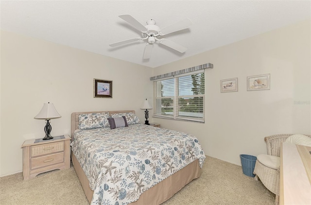 bedroom featuring a textured ceiling, light carpet, and ceiling fan