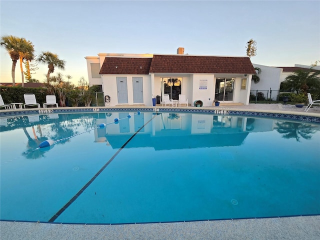 pool at dusk with an outdoor structure