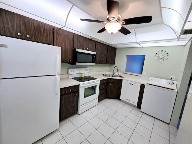 kitchen featuring white appliances, light tile patterned floors, sink, washer / clothes dryer, and dark brown cabinets