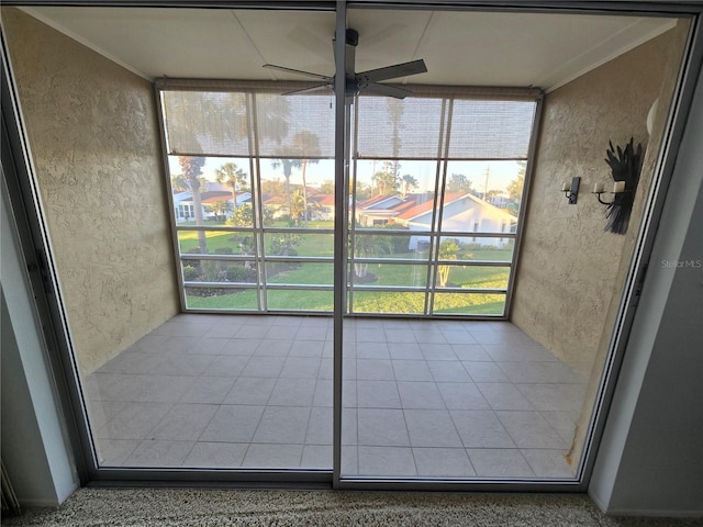 unfurnished sunroom featuring ceiling fan