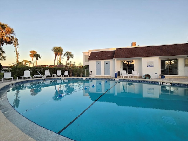 view of pool at dusk