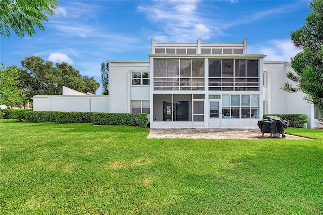 back of house featuring a lawn and a sunroom