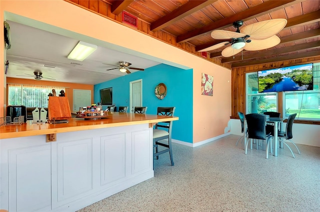 kitchen with a kitchen breakfast bar, wood ceiling, beamed ceiling, and a wealth of natural light