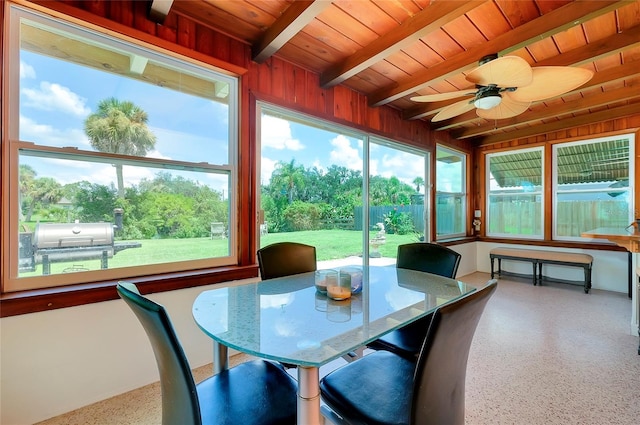 sunroom / solarium with a healthy amount of sunlight, beamed ceiling, wooden ceiling, and ceiling fan