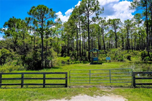 view of gate featuring a yard and a shed