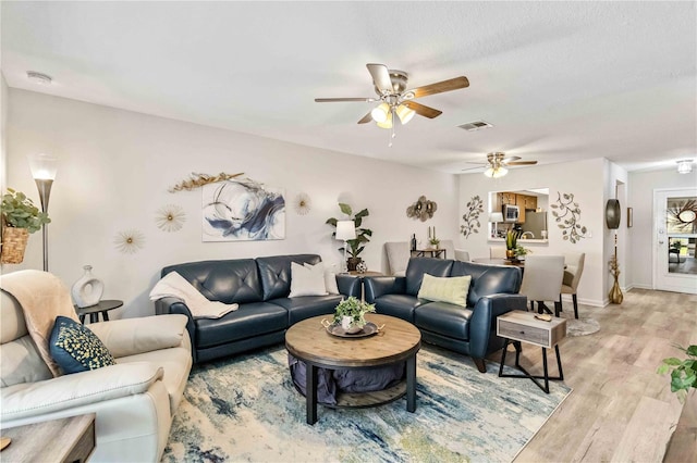 living room with light hardwood / wood-style floors and ceiling fan