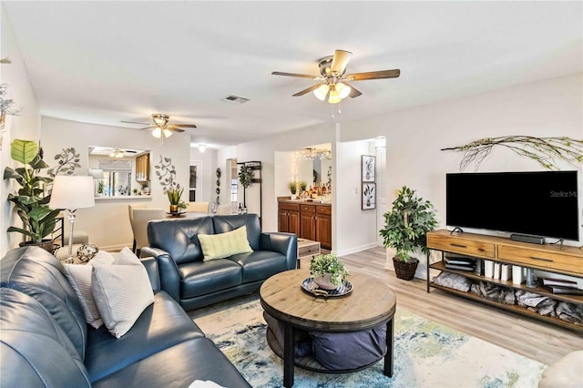 living room with ceiling fan and light hardwood / wood-style flooring