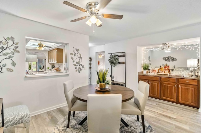 dining area featuring light hardwood / wood-style floors, sink, and ceiling fan