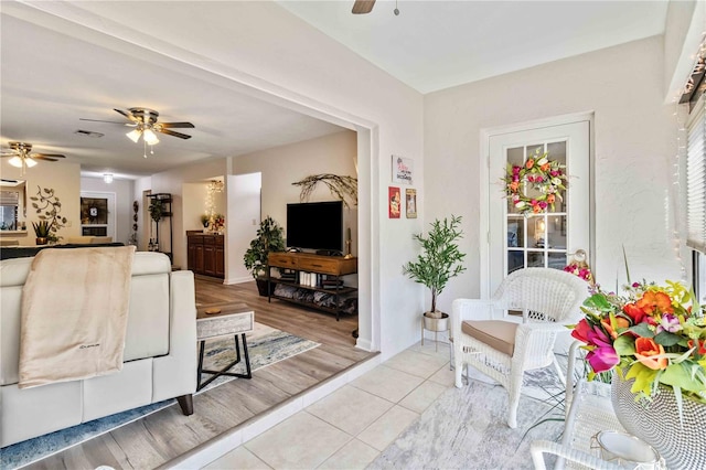 living room with ceiling fan and light hardwood / wood-style flooring