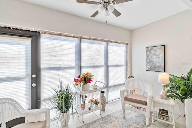 sitting room featuring light tile patterned flooring and ceiling fan