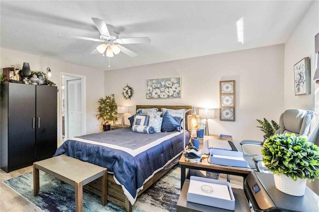 bedroom with a closet, hardwood / wood-style floors, and ceiling fan