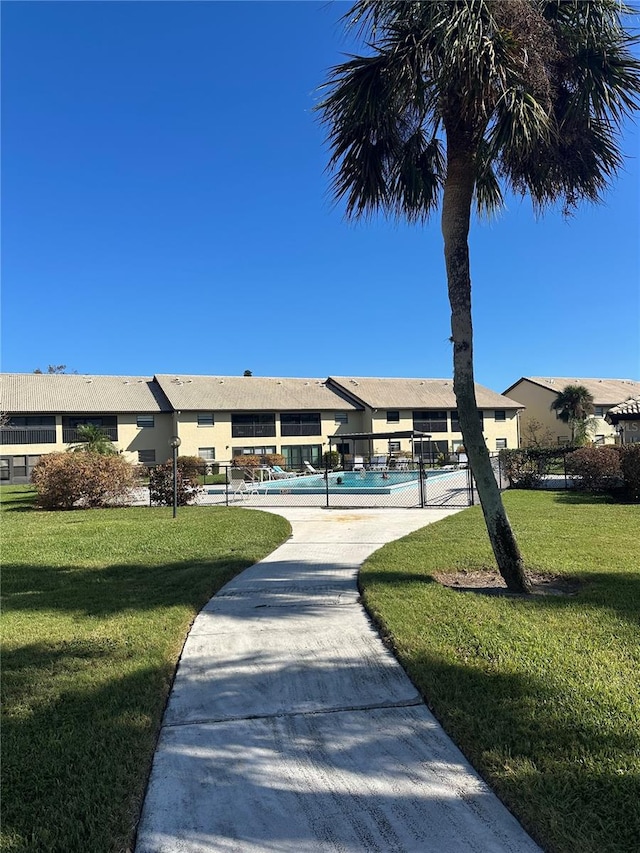 view of home's community featuring a yard and a pool