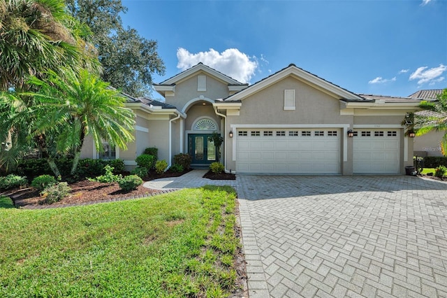 view of front of home with a front yard, french doors, and a garage