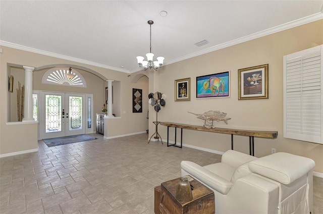 entryway with a chandelier, french doors, and crown molding