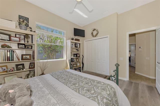 bedroom with hardwood / wood-style flooring, ceiling fan, and a closet