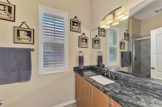 bathroom with vanity, a healthy amount of sunlight, and an enclosed shower