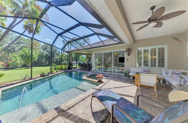 view of swimming pool featuring ceiling fan, a lanai, an outdoor living space, pool water feature, and a patio