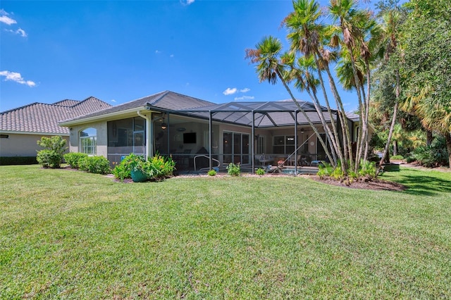 back of house featuring a lanai and a yard