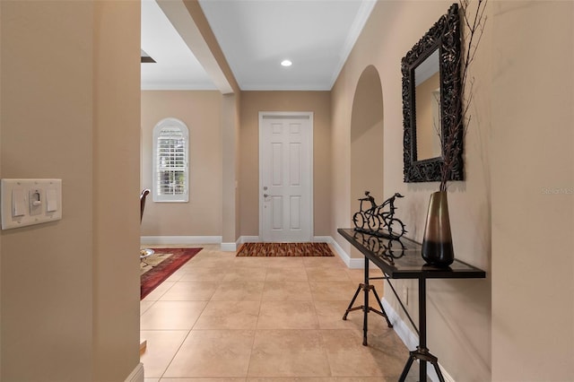 entrance foyer with ornamental molding and light tile patterned floors