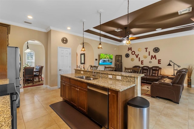 kitchen with light stone countertops, sink, ceiling fan, stainless steel appliances, and decorative light fixtures