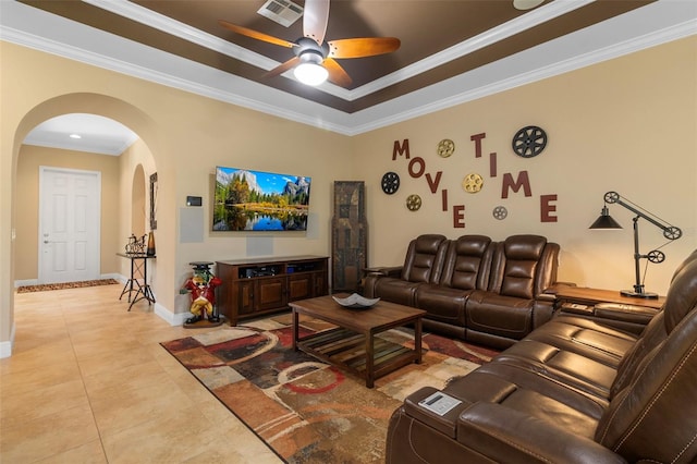 living room with ornamental molding, light tile patterned flooring, a tray ceiling, and ceiling fan