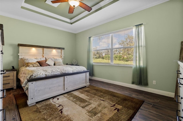 bedroom with dark wood-type flooring, crown molding, a tray ceiling, and ceiling fan