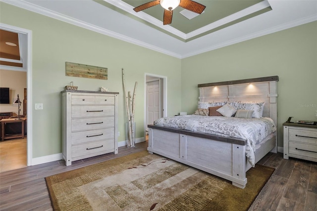 bedroom with ceiling fan, a raised ceiling, crown molding, and dark hardwood / wood-style floors