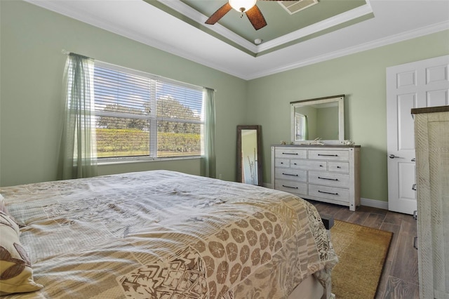 bedroom featuring ceiling fan, hardwood / wood-style flooring, ornamental molding, and a raised ceiling