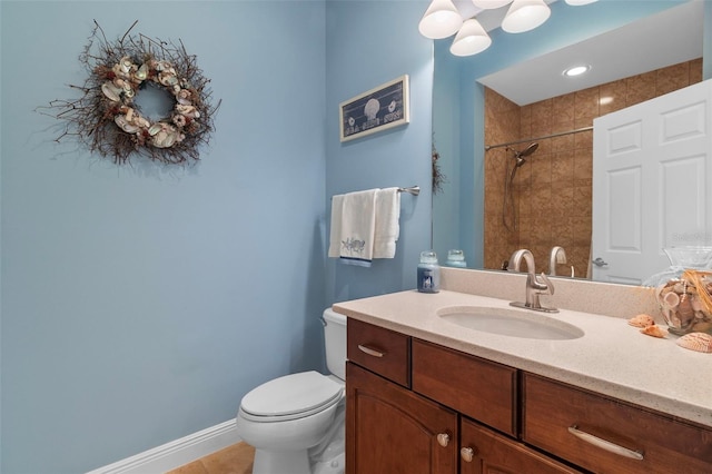 bathroom with toilet, tile patterned flooring, vanity, and tiled shower