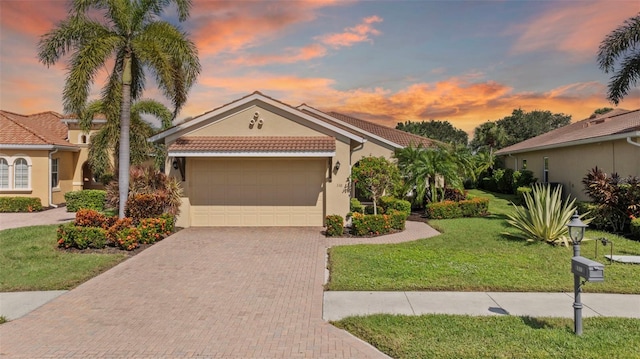 view of front of home with a garage and a lawn