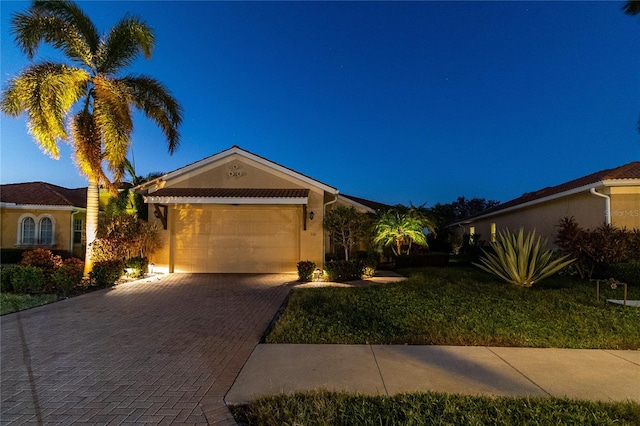 single story home featuring a front lawn and a garage