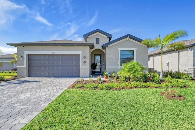 view of front of home with a front lawn, central AC unit, and a garage