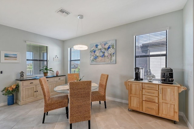 dining room with light tile patterned flooring and a healthy amount of sunlight