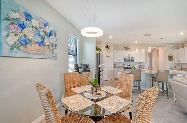 dining area featuring sink and light tile patterned floors