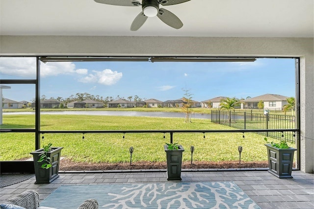 unfurnished sunroom featuring a water view and ceiling fan