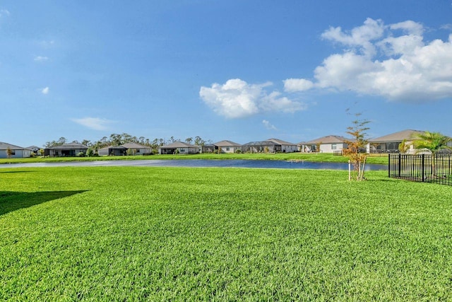 view of home's community featuring a water view and a yard