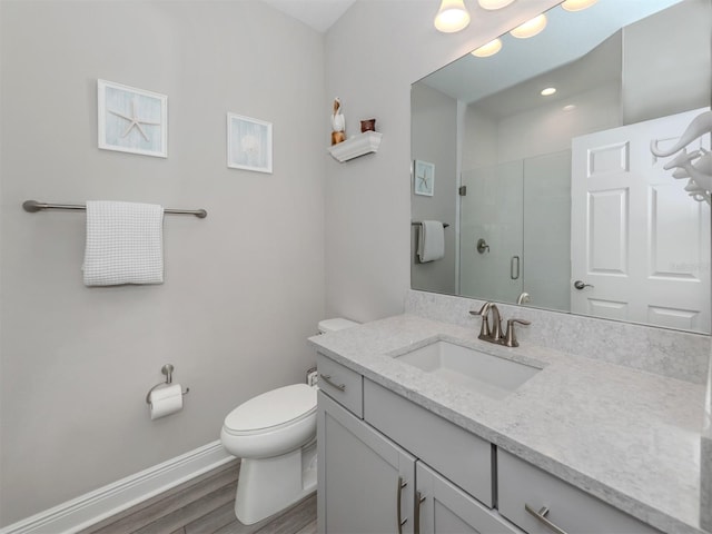 bathroom with vanity, walk in shower, toilet, and wood-type flooring