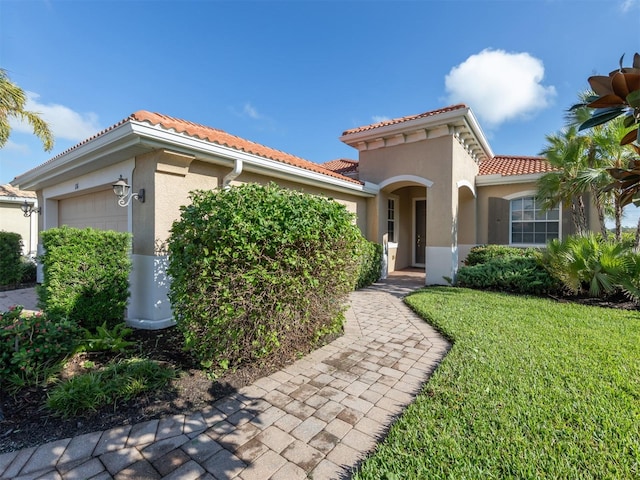 mediterranean / spanish house with a front lawn and a garage