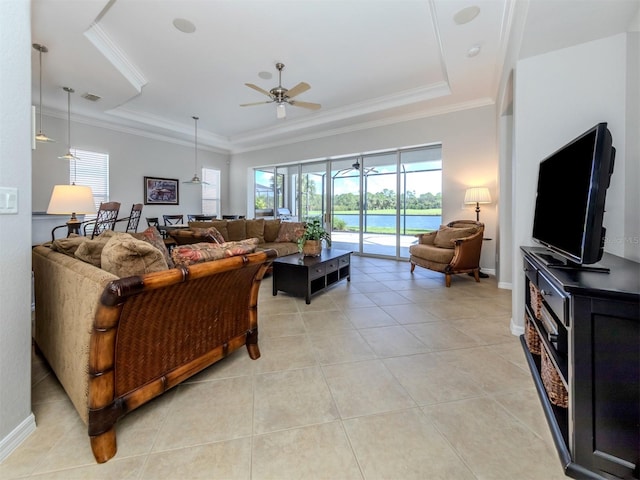 tiled living room featuring ornamental molding, ceiling fan, and a raised ceiling