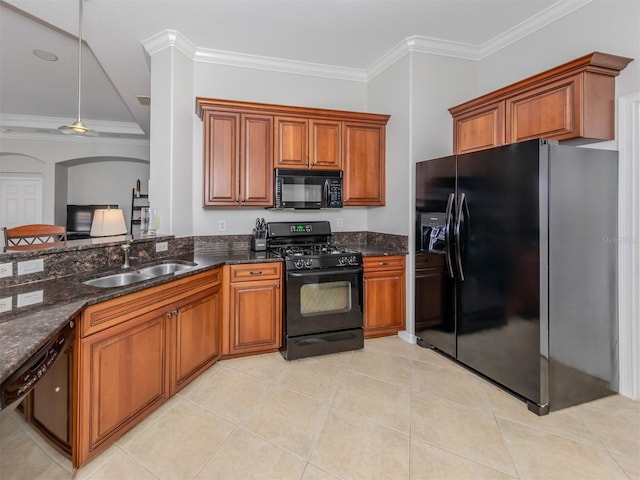 kitchen with light tile patterned floors, sink, black appliances, dark stone countertops, and crown molding