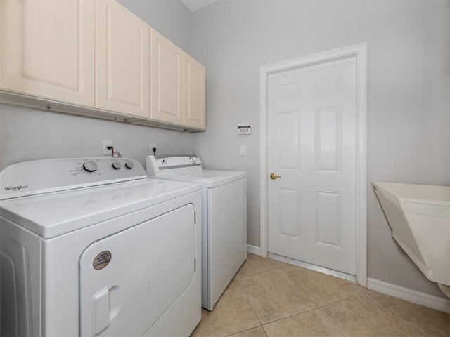 126 Cipriani Way N, Venice, FL 34275 - washroom featuring washing machine and dryer, baseboards, cabinet space, and light tile patterned floors