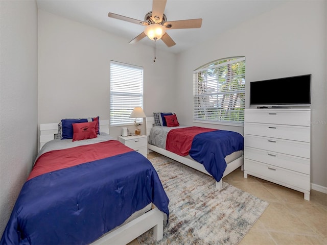 bedroom featuring light tile patterned floors, multiple windows, and ceiling fan