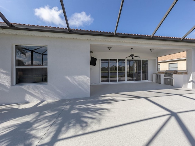 back of house featuring exterior kitchen, a patio, a lanai, and ceiling fan