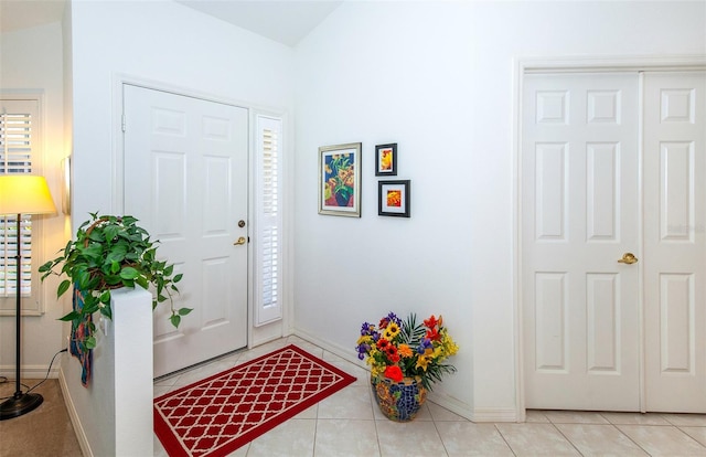 tiled entrance foyer featuring lofted ceiling and a healthy amount of sunlight