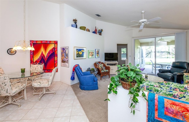 tiled living area with visible vents, vaulted ceiling, and ceiling fan with notable chandelier
