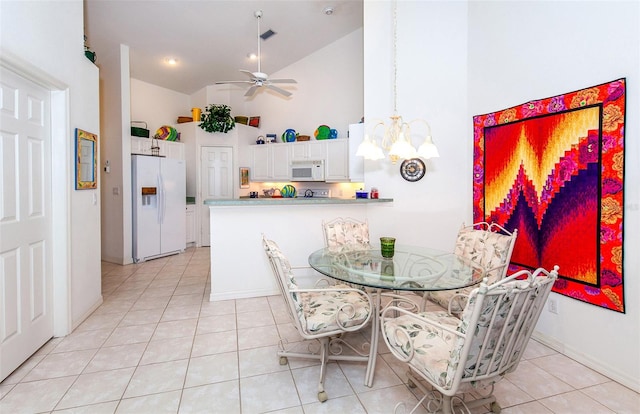 tiled dining room with ceiling fan and high vaulted ceiling