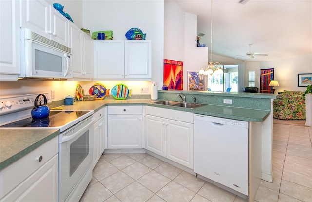 kitchen featuring a sink, a peninsula, light tile patterned floors, and white appliances