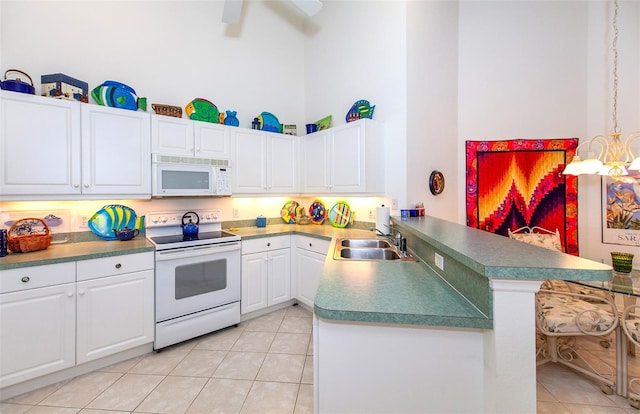 kitchen featuring light tile patterned flooring, kitchen peninsula, white appliances, white cabinetry, and a towering ceiling