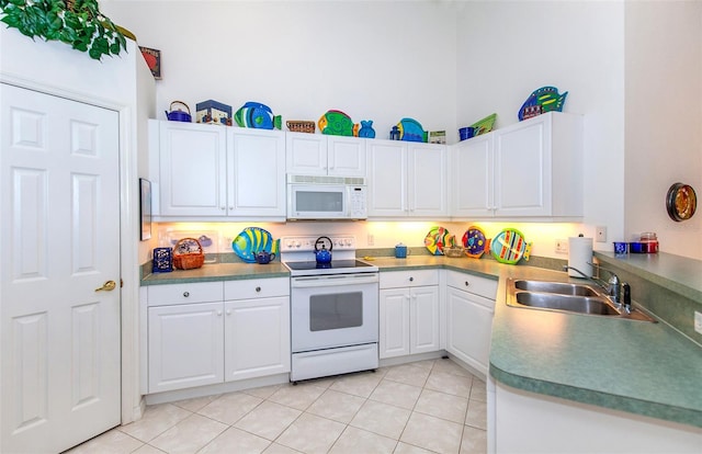 kitchen with white cabinets, light tile patterned floors, sink, white appliances, and a high ceiling