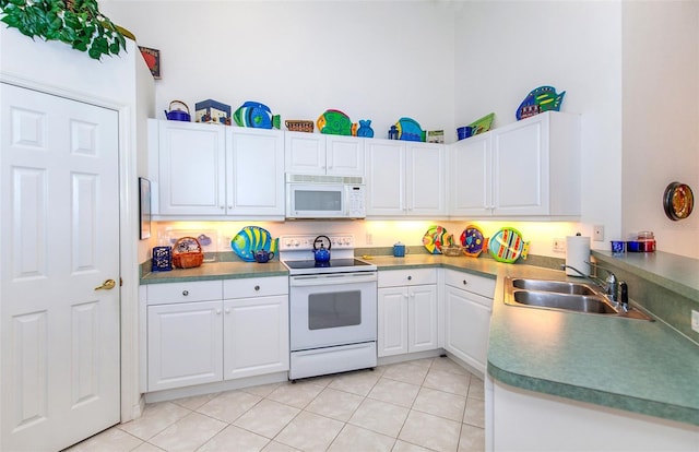kitchen featuring a sink, light tile patterned floors, white cabinets, and white appliances